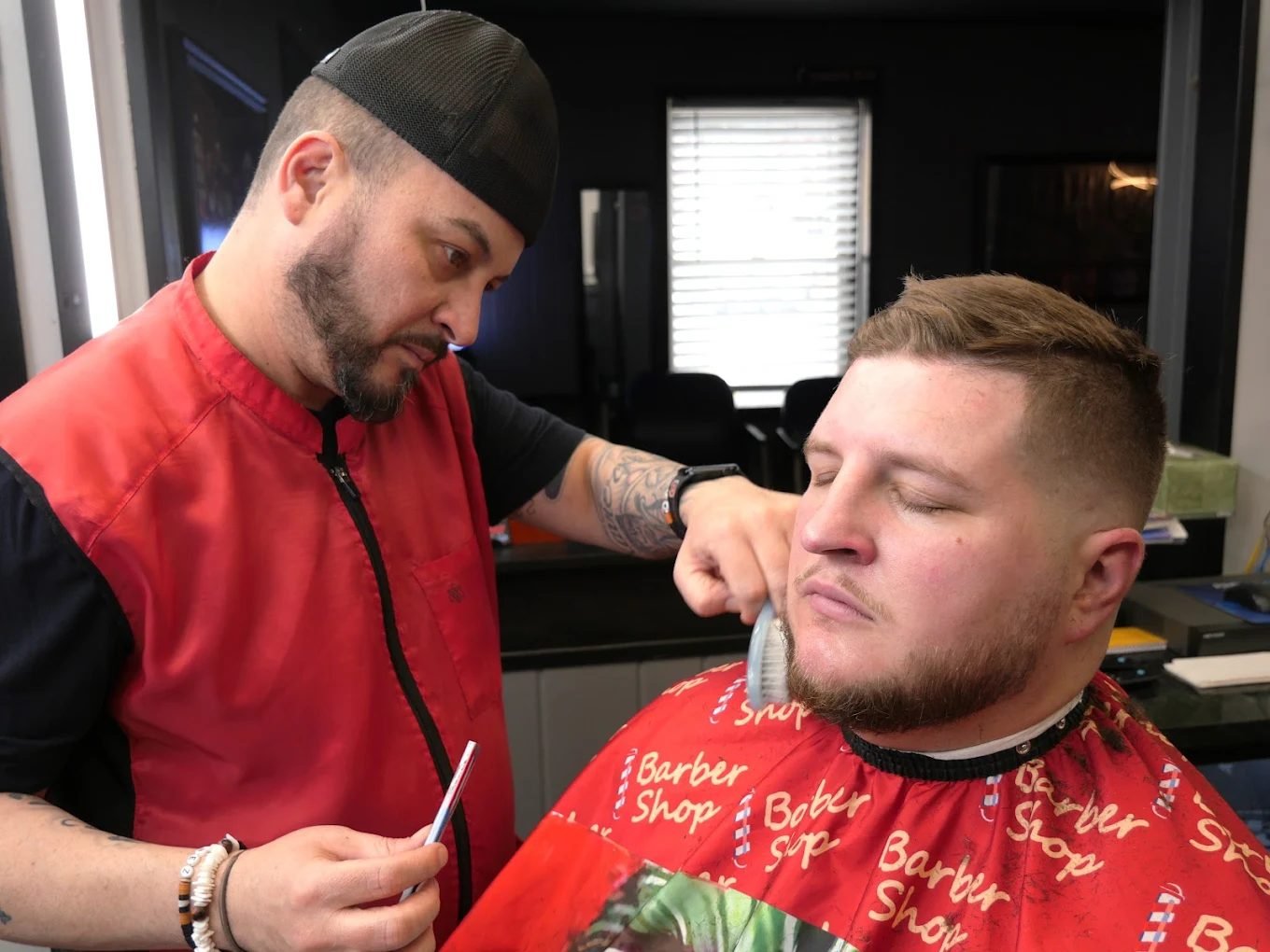 Barber brushing out a client's beard