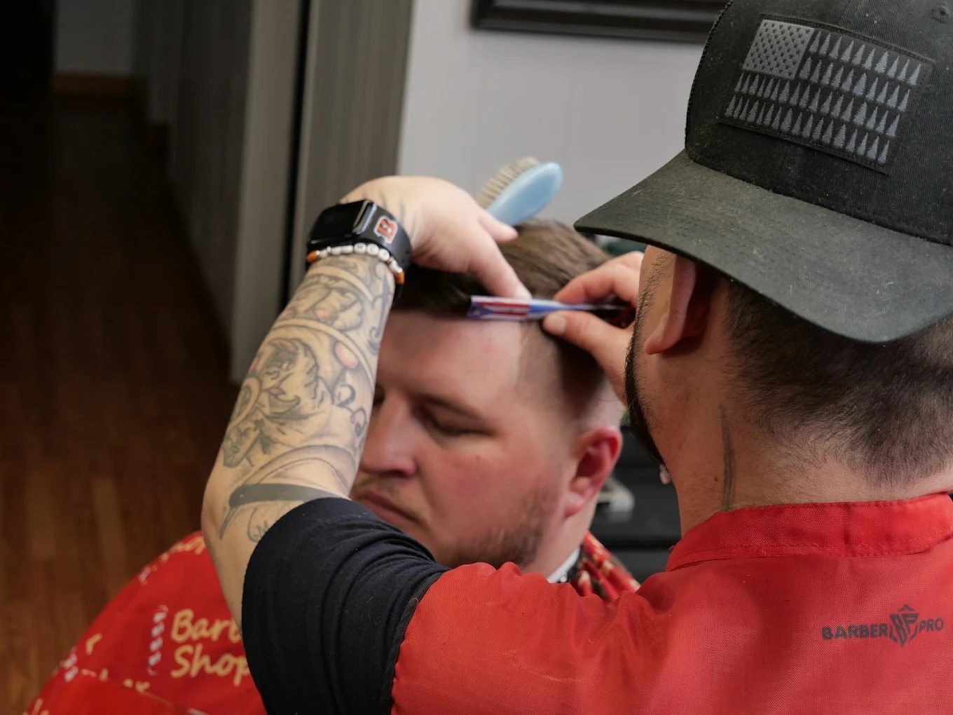 Razor line-up on a skin fade, seen over the barber's shoulder