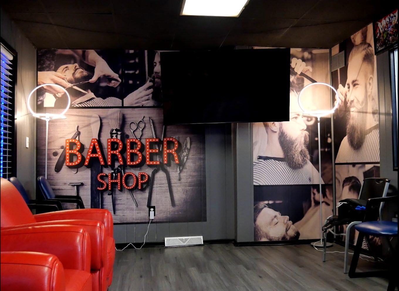 MVB waiting area with red leather chairs and a lit Barber Shop sign