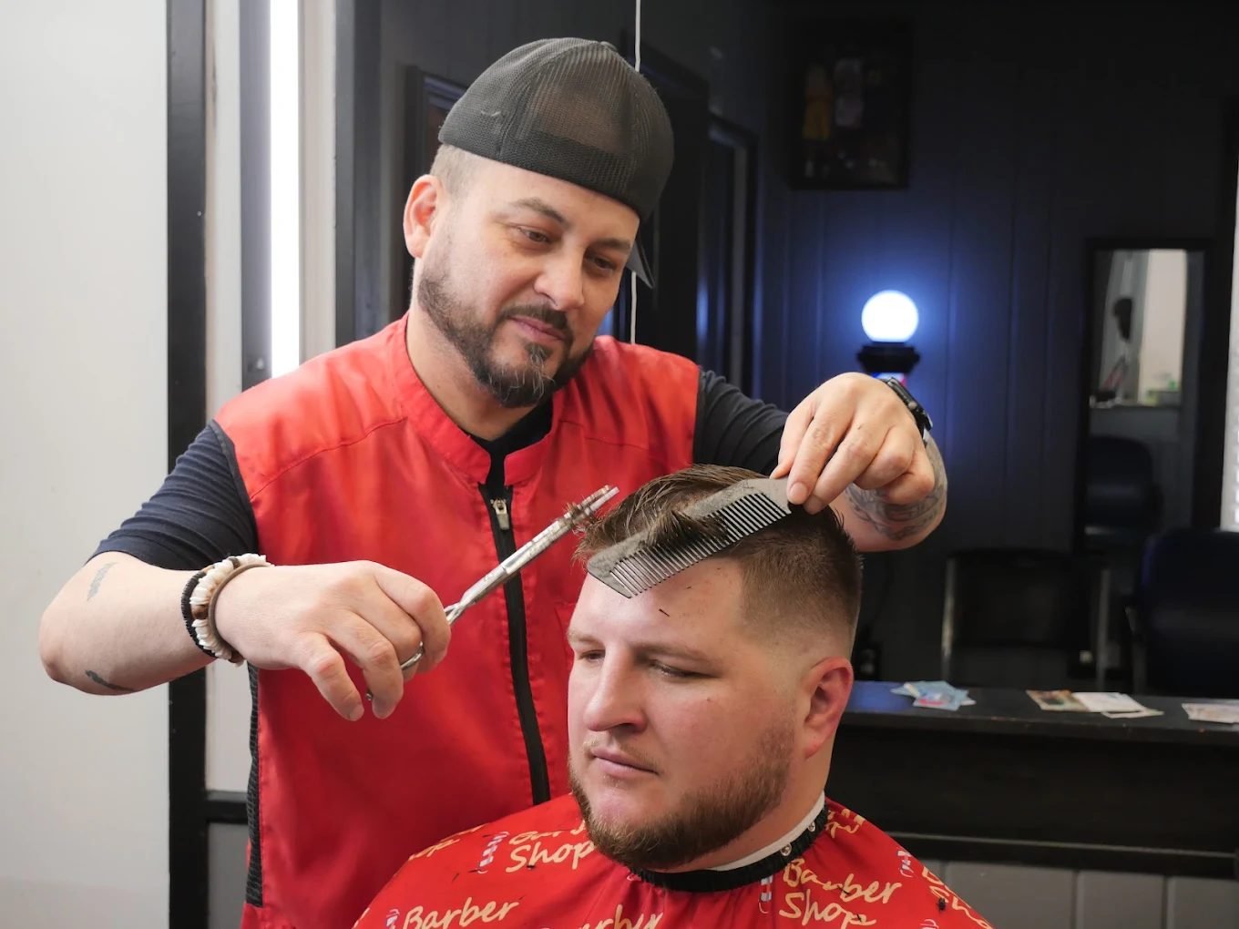 Barber cutting with scissors and comb