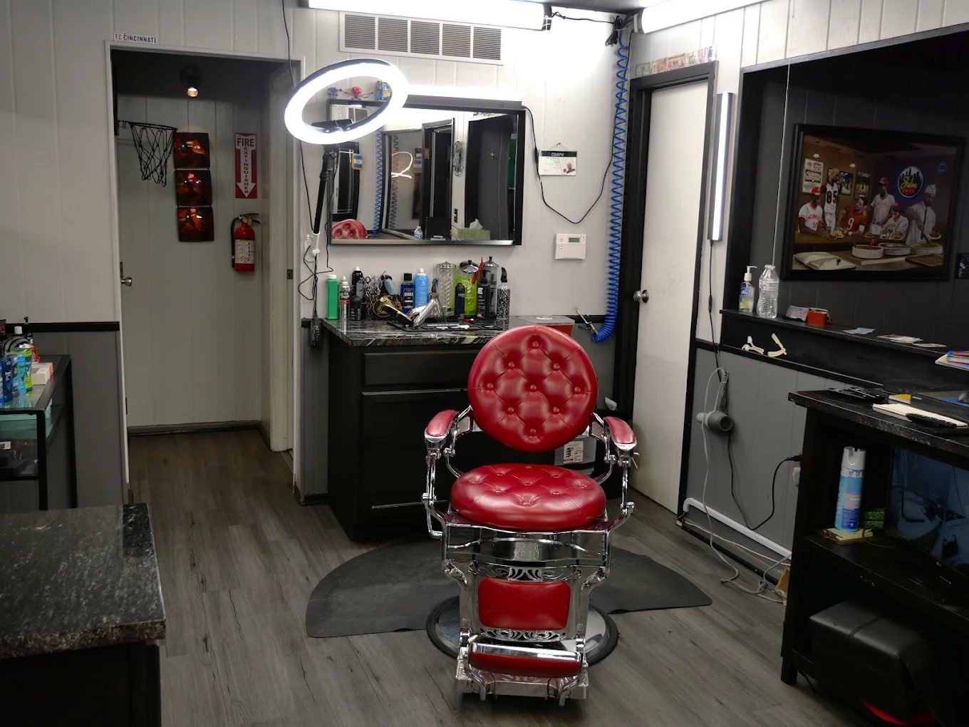 Red tufted barber chair at a station with a ring light
